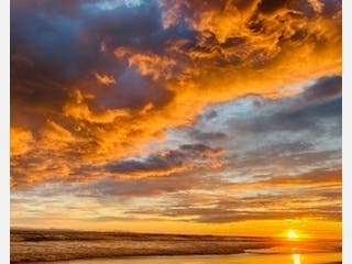 An inspiring sunset opens up over the ocean at Newport Beach, Calif. 