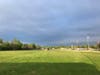 The sun shines on a large, green field. 