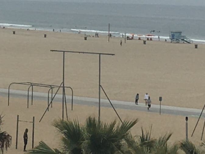 People walk along the hazy shore in Santa Monica. 