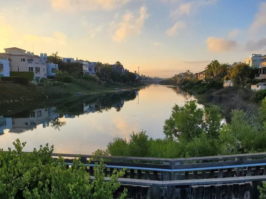 The sky is reflected in the clear water at Ballona Creek in Marina del Rey.