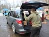 Volunteers loading cars with the food during "Kiwanis Club of Greater Roxbury Holiday Food Distribution"