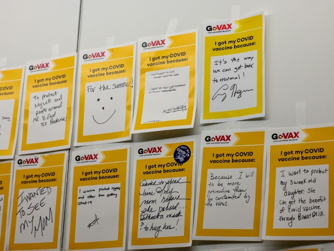 People write notes celebrating receiving the COVID-19 vaccine.
