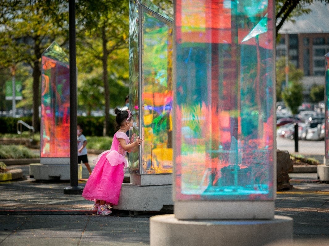 A young "princess" checks out Prismatic, a participatory installation with 25 pivoting prisms which light up after nightfall in the Outdoor Plaza.