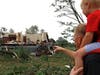 Woodridge, Ill., resident Jesse Wallace points out one of the severely damaged homes to his three-year-old son Chris Wallace, after a tornado passed through the area on Monday, June 21, 2021. (AP Photo/Shafkat Anowar)