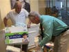 Project Self-Sufficiency's Dick Kowal and Brian Westervelt prepare bags of food for distribution.