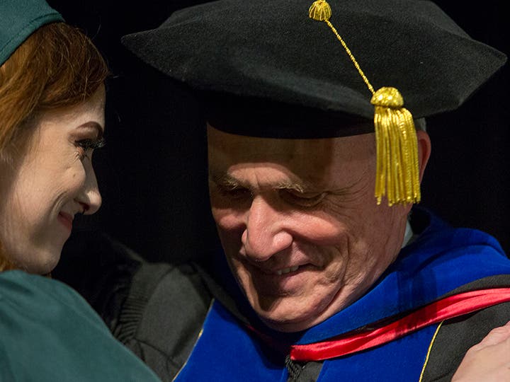 Interim College of DuPage President Dr. Brian Caputo presents his daughter, Kadie, with her diploma. (Photo by Press Pho