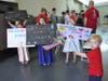 Young family members hold signs as soldiers return Friday from an overseas deployment.