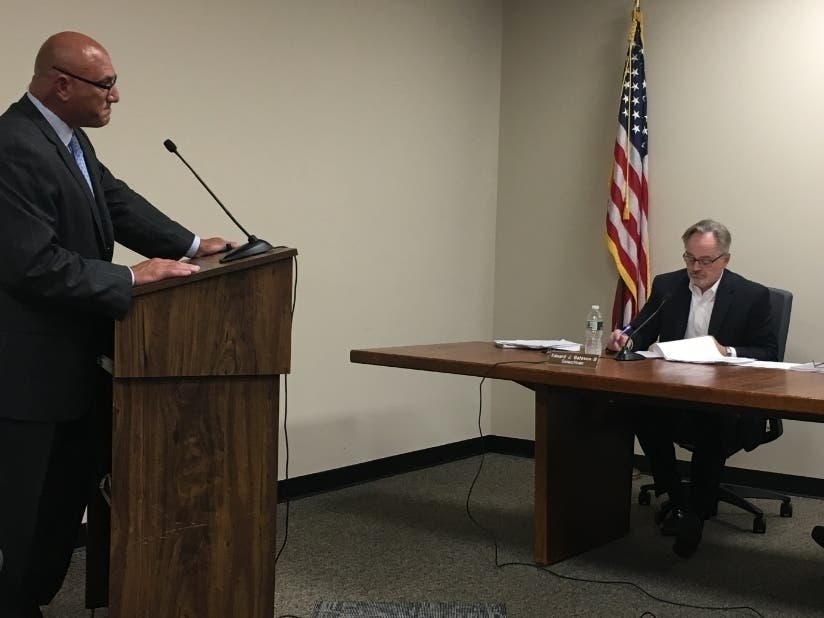 Human Resources Director Emmet Hibson speaks before selectmen, including Ed Bateson (right), at a meeting in early September.