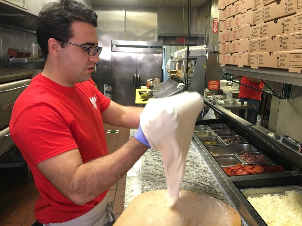 Owner Arben "Benny" Ajruli shapes pizza dough at Di Roma's Pizza & Italian Eatery.
