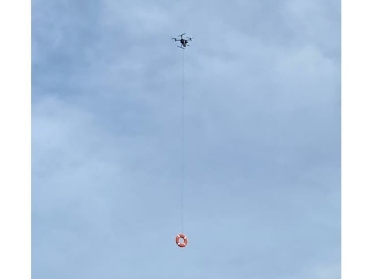 A drone holds a flotation device. Fairfield police have been training to use drones to bring flotation devices to swimmers in distress.