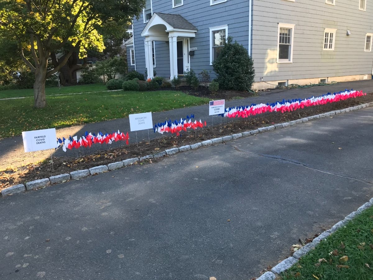 Flags memorializing Fairfield County residents who died of the coronavirus line Meg Murray's driveway in Stratfield.