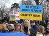 Attendees hold up signs at a rally Saturday to support Ukraine.