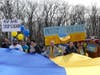 Attendees hold up signs at a rally Saturday to support Ukraine.
