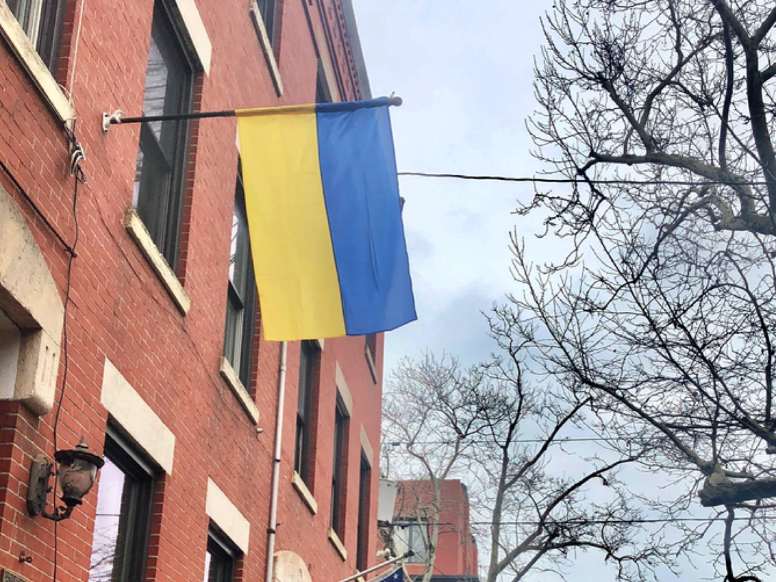 A Ukrainian flag flies outside an apartment building.