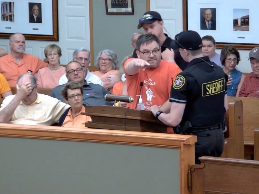 Joel Trudell is taken into custody Tuesday at a county board meeting.