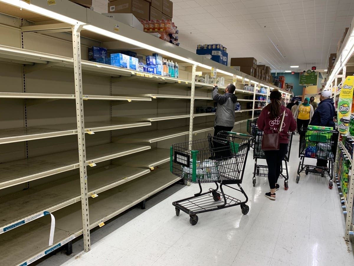 Customers clear shelves of water Sunday at Fresh Grocer in West Philadelphia.