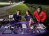 Lucia Cook, Golda Gadarian, and Damian Attidore sell purple items to raise awareness about domestic abuse