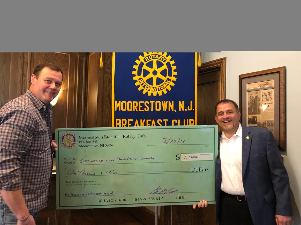 Rotary President Grant Leuliette presents a $1,000 check to Board Member George Gravenstein.