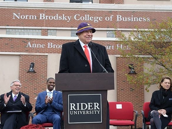 Norm Brodsky speaks at a dedication ceremony Thursday, wearing the purple and gold beanie customarily worn by Rider freshmen of his day.