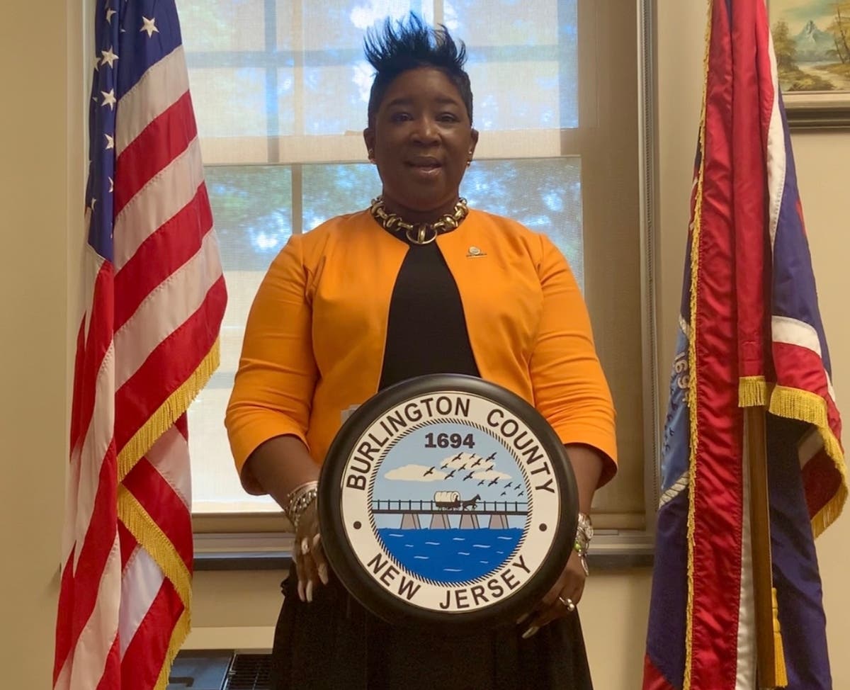  Burlington County Board Director Felicia Hopson speaks from a podium with a revised County seal, which no longer displays the name “Board of Chosen Freeholders.”
