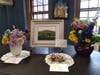 One of the flower arrangements and three pieces of artwork from Art in Bloom 2019