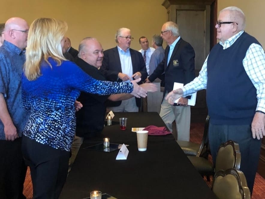 Scott Robinson, chief executive officer of the Cathedral City Boys and Girls Club, and others approach Christopher McGuire, president of the H.N. and Frances C. Berger Foundation, to thank him for an unexpected $5,000 grant.