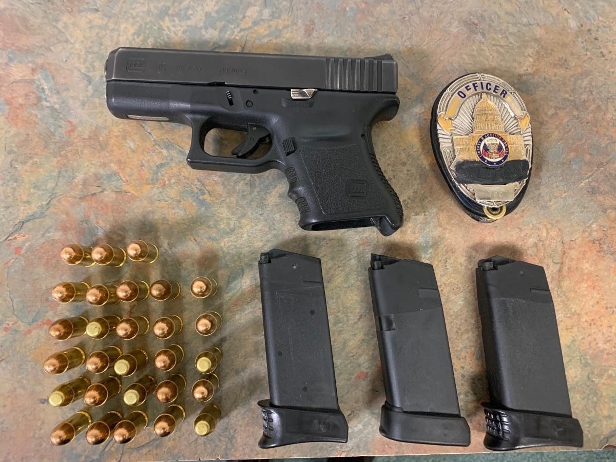 The loaded .45 caliber pistol, several additional rounds of ammunition and a fake badge found during the investigation.