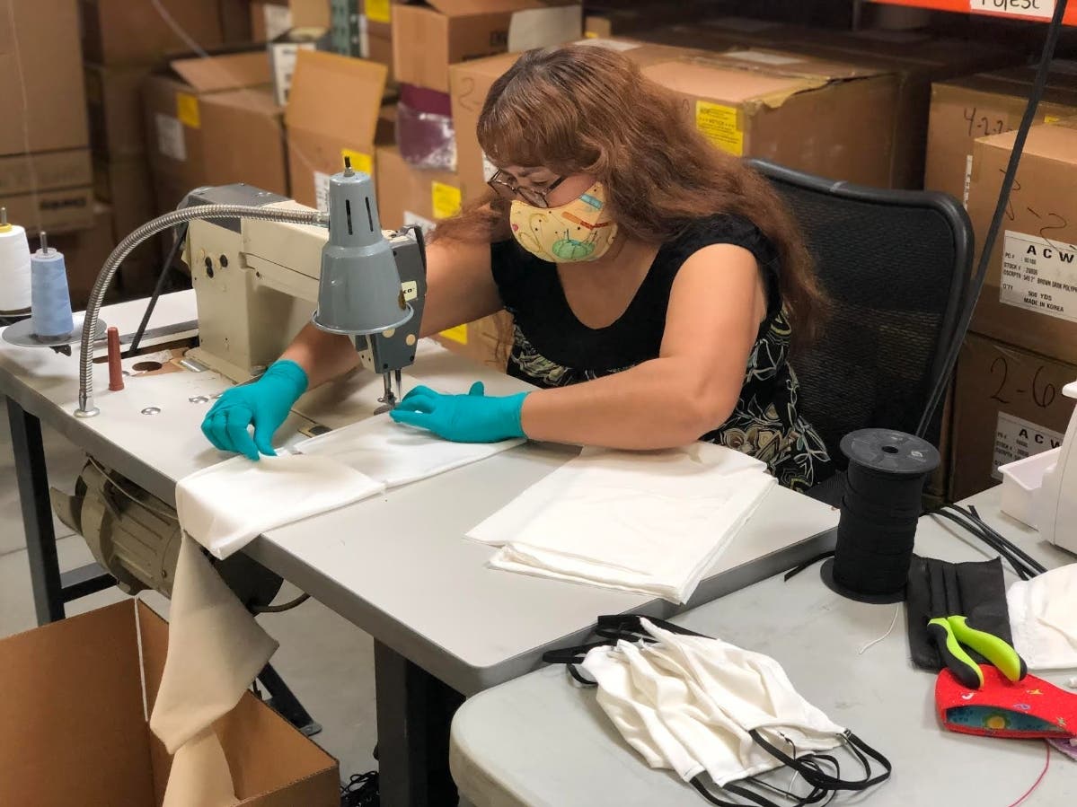 An employee makes face masks at the Ernie Ball plant in Coachella.
