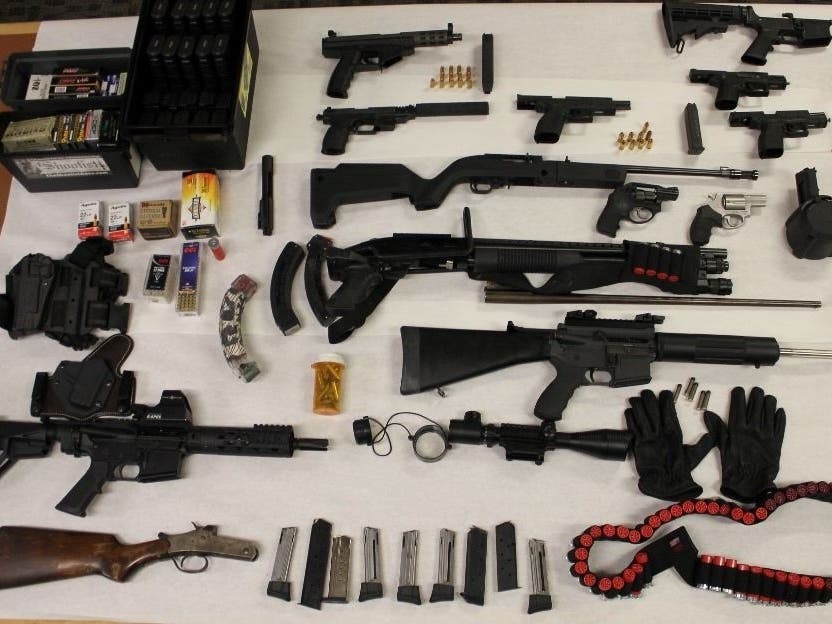 The suspect's alleged weapons cache (shown) included 13 firearms, including a suppressed handgun, several assault rifles and an allegedly stolen handgun.